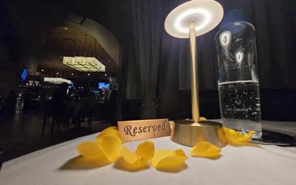 Reserved sign with yellow rose petals at Ocean Prime Orlando anniversary dinner table