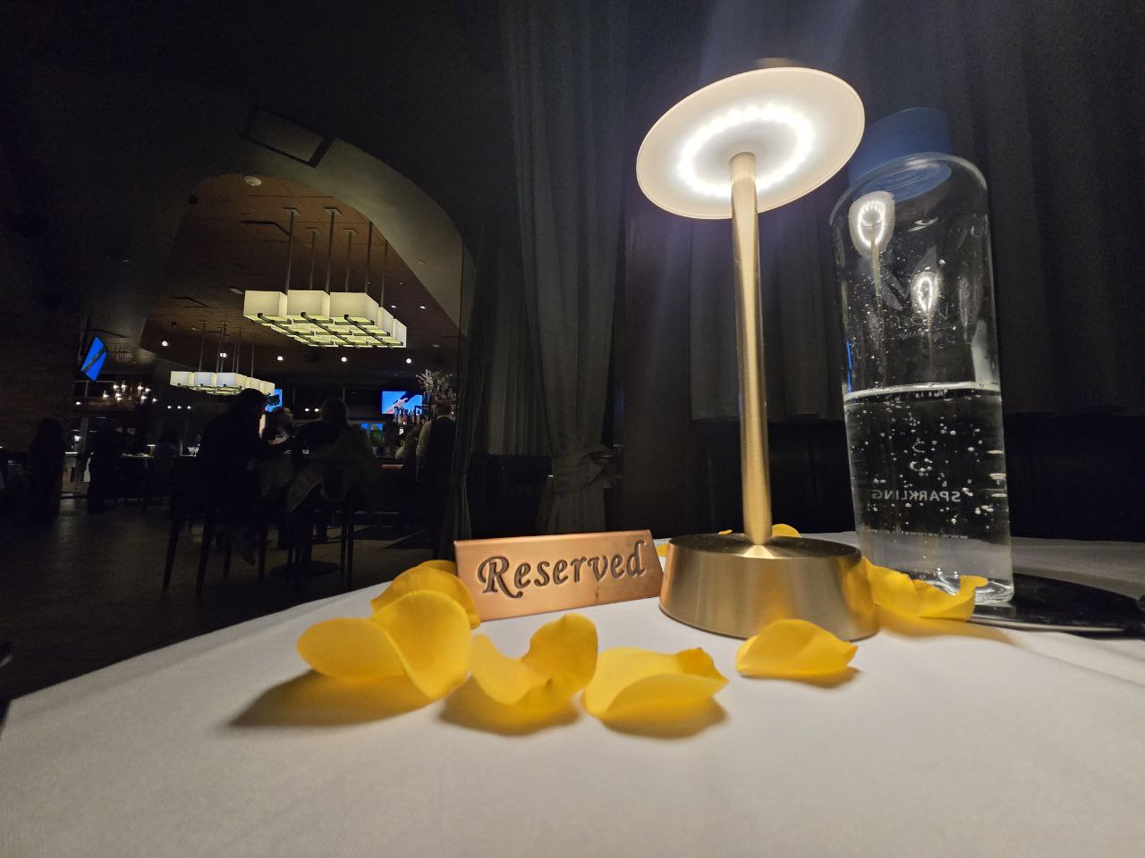 Reserved sign with yellow rose petals at Ocean Prime Orlando anniversary dinner table