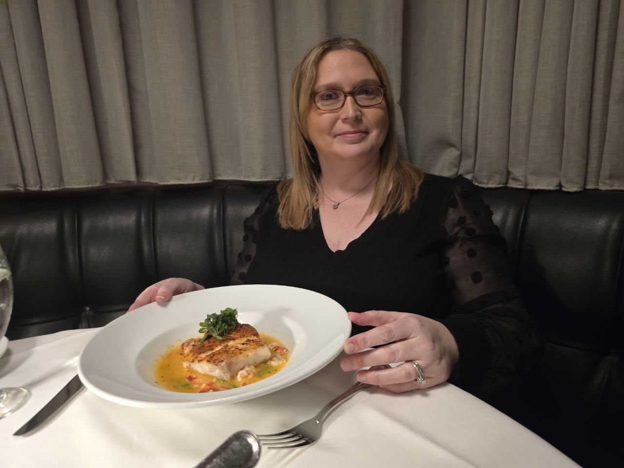 Kristy holding her grouper plate at Ocean Prime Orlando