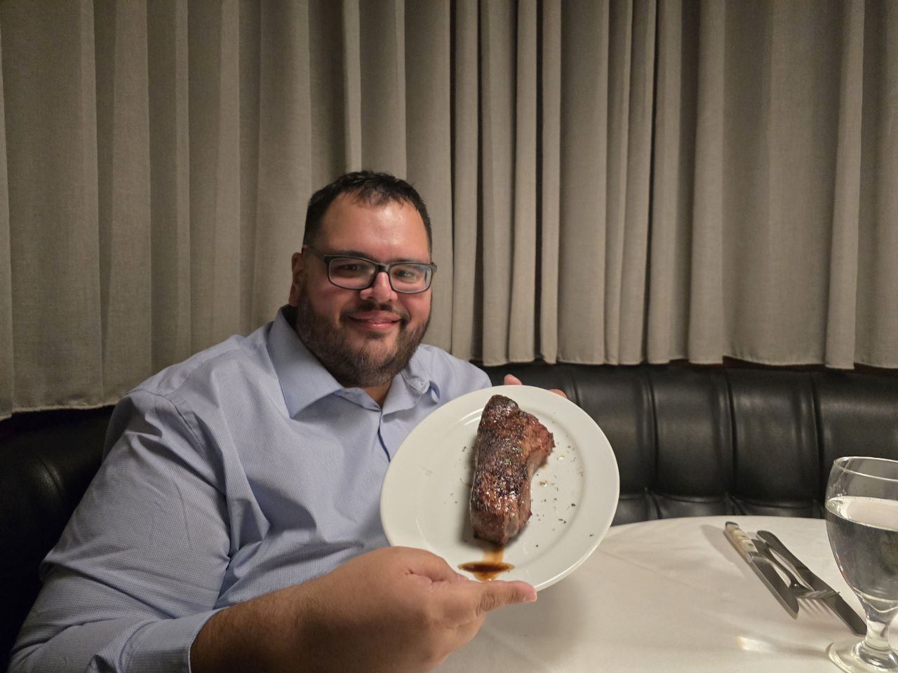 Jonathan holding his 14oz New York Strip at Ocean Prime Orlando